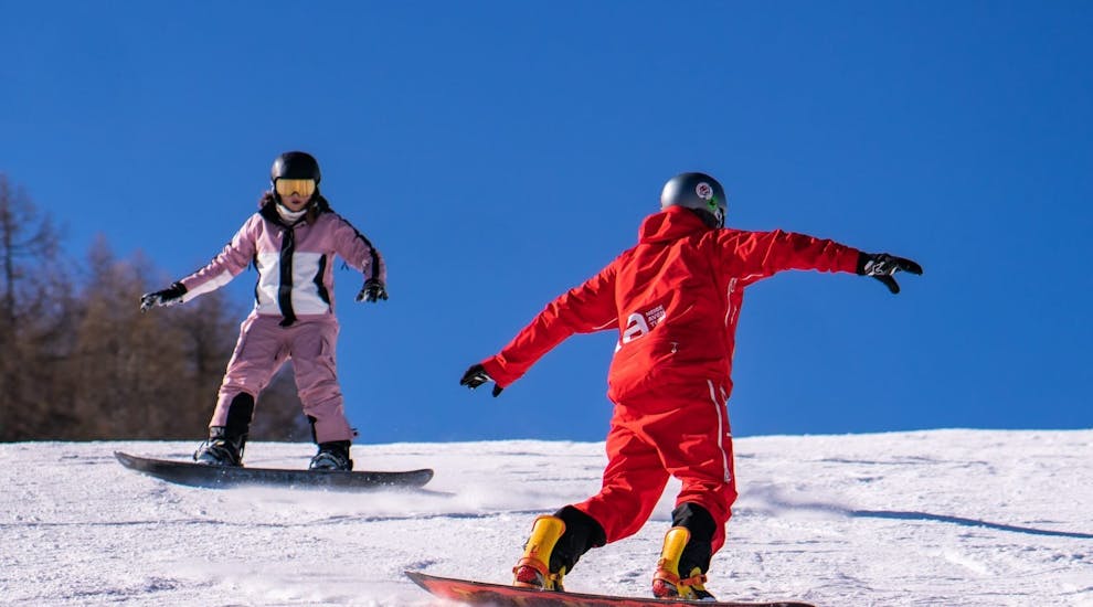 Image d'un adolescent et son moniteur pendant un cours privé de snowboard avec Neige Aventure.
