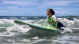 Chica tomando clases particulares de surf (a partir de 10 años) en la playa de Matosinhos, cerca de Oporto, en el Surfing Life Club Porto.