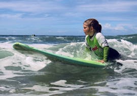 Chica tomando clases particulares de surf (a partir de 10 años) en la playa de Matosinhos, cerca de Oporto, en el Surfing Life Club Porto.