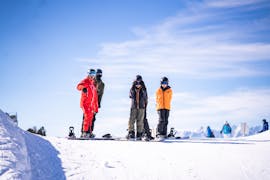 Photo de 3 amis avec leur moniteur pendant un cours de snowboard avec Neige Aventure.