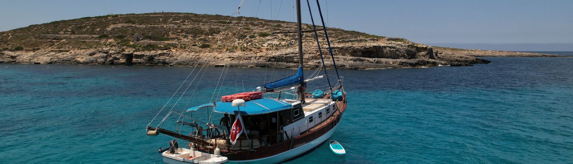 The boat Gulet KelSea is floating in the ocean while Gulet Boat Rental in Sliema (up to 25 people) with Skipper organized by Malta Gulet Charters.