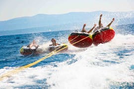 A group of friends enjoy a Banana Boat and Crazy Sofa Rides at Anassa Beach from Latchi Dive & Watersports Centre.