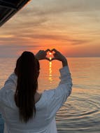 Fille appréciant la vue du coucher de soleil durant sa Balade au coucher de soleil en bateau semi-rigide depuis Nice vers Saint-Jean-Cap-Ferrat et Villefranche-sur-Mer avec Apéritif avec Nissa Croisières.