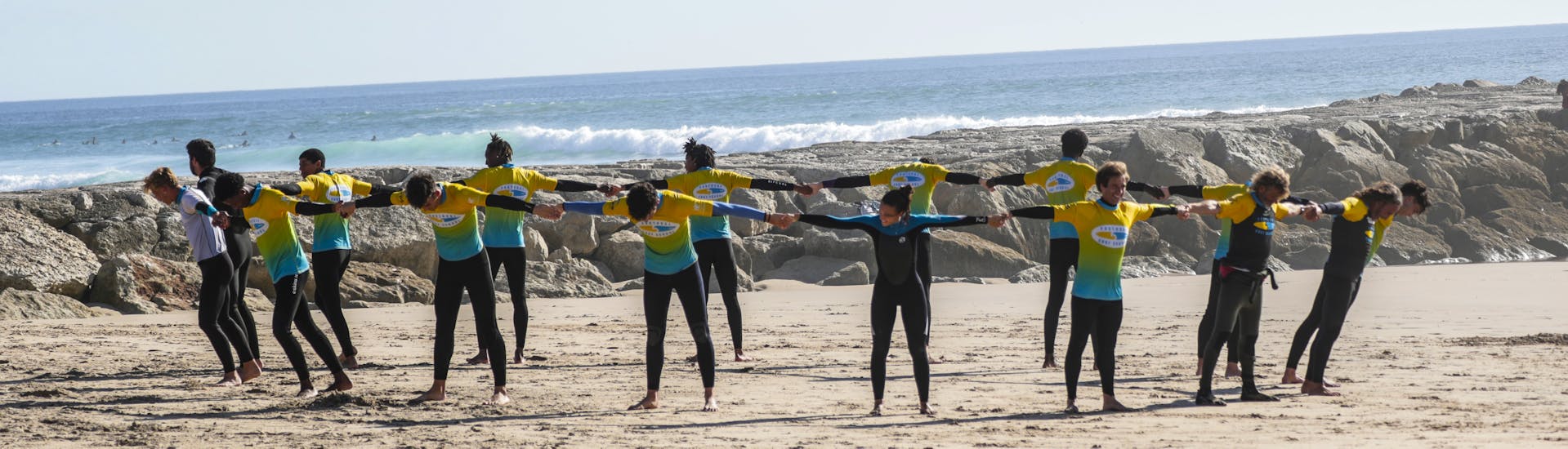 Warm-up oefening tijdens Surflessen (vanaf 6 j.) in Costa da Caparica.