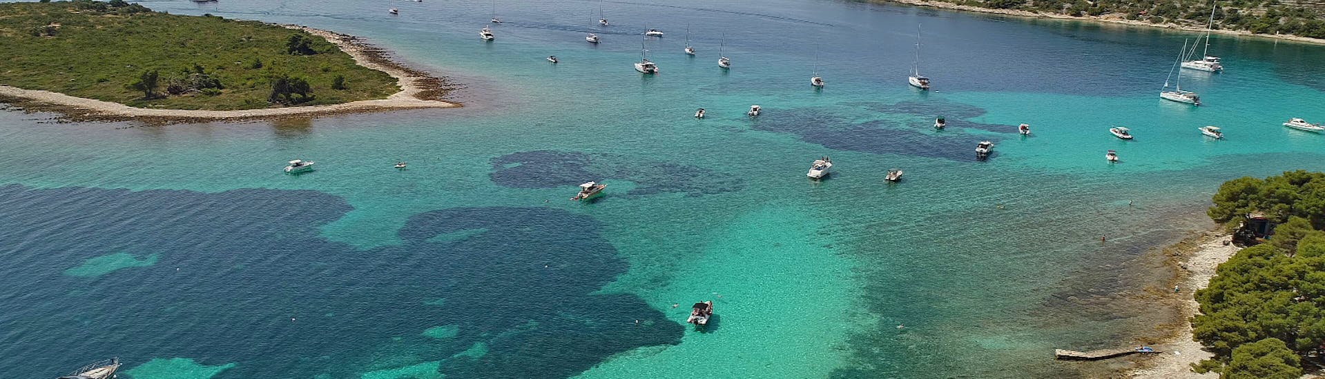 Een uitzicht van bovenaf van alle boten rondom de eilanden tijdens de halve dag boottrip naar Blue Lagoon, Solta-eiland en Duga Cove met Leo Tours.