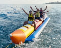 Grupo de chicos disfrutando en un paseo en barco con forma de de plátano inflable en Villajoyosa con Todajet Benidorm.