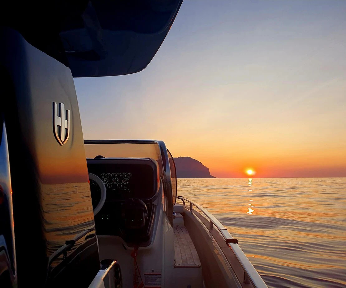Una vista da una barca cattura il sereno tramonto sul mare durante un'escursione privata in barca da Palermo a Mondello con aperitivo e snorkeling.
