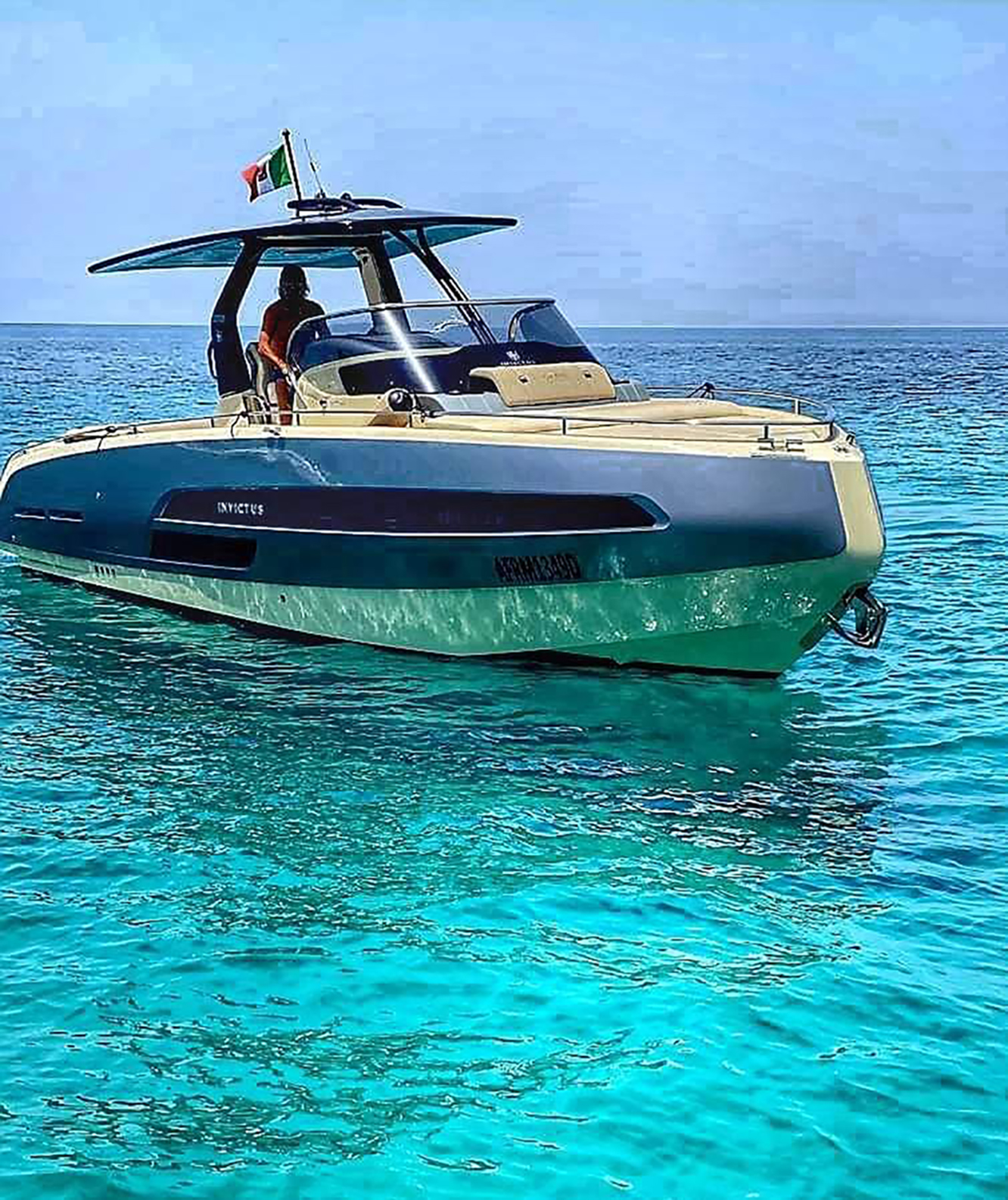 Un moderno motoscafo galleggia sulle acque limpide e turchesi del Mar Mediterraneo durante un'escursione privata da Palermo a Mondello con aperitivo e snorkeling, offerta da Sea Tour Palermo.