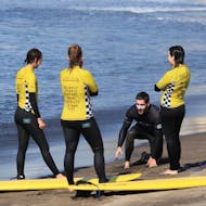 Instructor explaining something to his students at the beach with at a Surf Lessons (from 10 y.) in the Azores from Azores Surf Club - Watergliders.