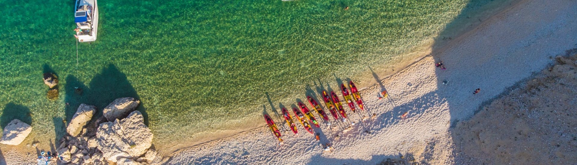 A picture taken from above with all the kayaks laying on the beach during the Sea Kayaking in Pag Bay from Sunturist.