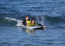 Instructor helping someone ride a wave with the Private Surfing Lessons (from 10 y.) in the Azores from Azores Surf Club - Watergliders.