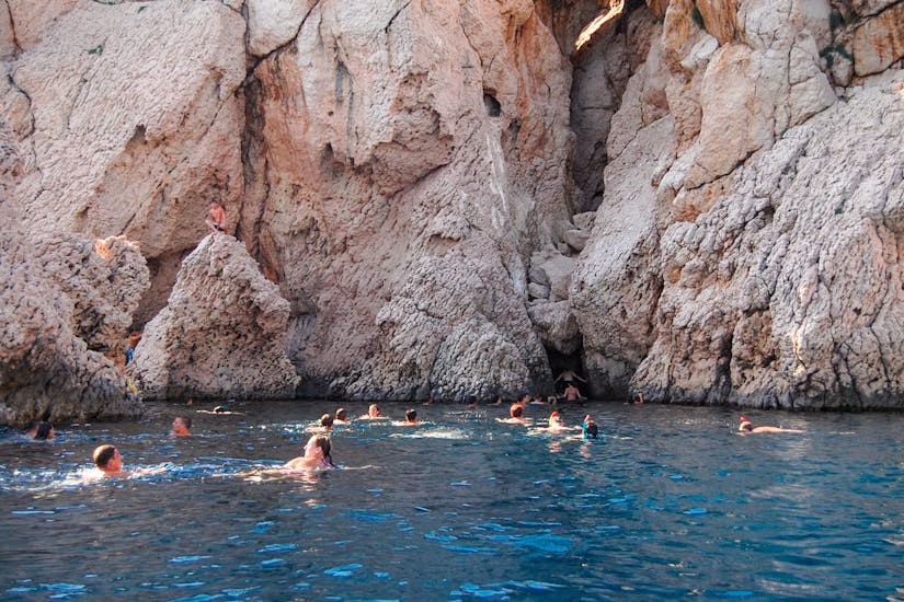 People swimming in front of some caves during the Boat Trip in Pag Bay with Lunch and Swimming from Sunturist Novalja.