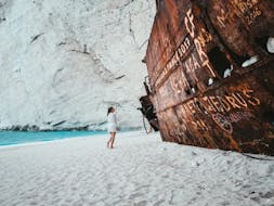Woman next to Shipwreck on Shipwreck Beach during Early Morning Minivan & Boat Trip to Shipwreck Beach & Blue Caves from Dali Tours Zakynthos.