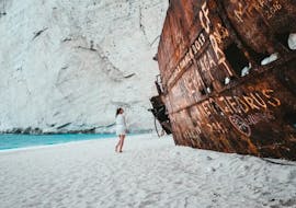 Woman next to Shipwreck on Shipwreck Beach during Early Morning Minivan & Boat Trip to Shipwreck Beach & Blue Caves from Dali Tours Zakynthos.