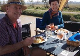 Deux personnes en pleine croisière privée sur le Canal du Midi entrain de manger.