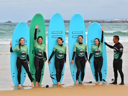Un groupe d’amies montrant leur planche lors de leurs cours de surf sur la plage de Peniche avec G3Store Surf Center Peniche.