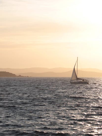 Giro in barca a vela al tramonto lungo la costa di Alghero con aperitivo e SUP.