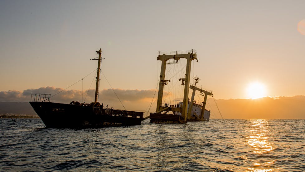 Das Schiffswrack von Manassa Rose vor einem orangenen Hintergrund während der Kajak-Tour von Kissamos zu Manassa Rose mit Schwimmstop bei Sonnenuntergang.