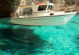 A boat is floating on crystal clear water while doing a Private Party Boat Trip to Blue Lagoon & Crystal Lagoon organized by Aloha Boat Charters Malta.