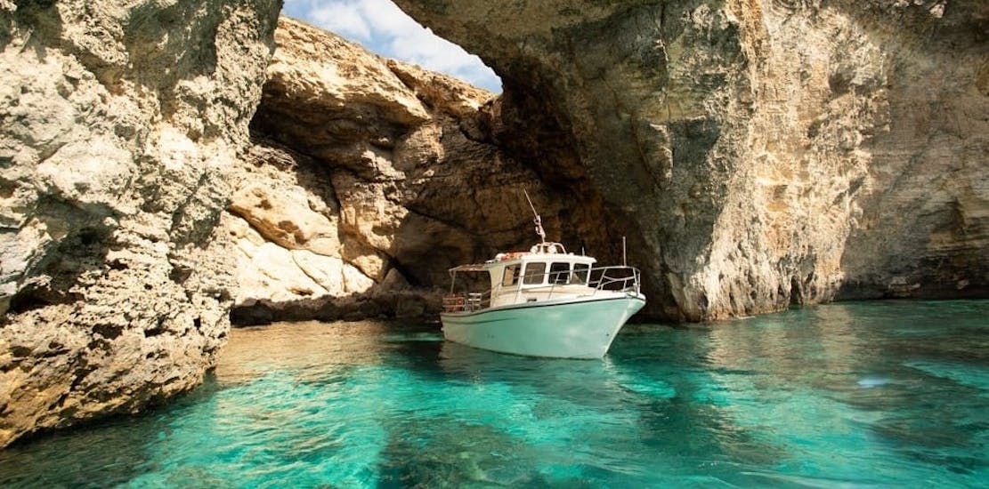 A boat is navigating through the caves while doing a Private Party Boat Trip to Blue Lagoon & Crystal Lagoon organized by Aloha Boat Charters Malta.