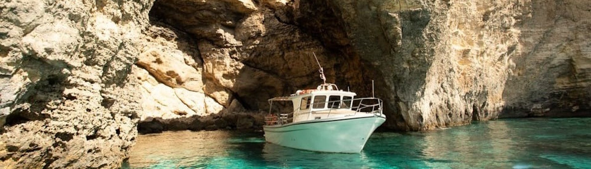 Ein Boot steuert durch die Höhlen während der Privaten Party-Bootstour zur Blue Lagoon & St Mary´s Bay organisiert von Aloha Boat Charters Malta.