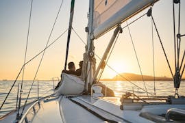 A couple enjoys a Sunset Sailboat Trip in Barcelona with Drinks & Snacks from Vela Boat Trips Barcelona.
