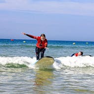A kid surfing during the Surf Lessons (from 8 y.) at Armação de Pêra Beach from Blue Xperiences Algarve.