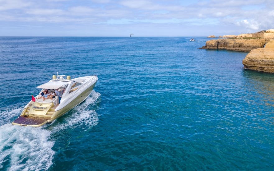 A yacht sails along the coast while doing a Private Boat Trip from Albufeira along the Algarve to the Benagil Cave with Snorkeling organized by EasyDream Charters Albufeira.