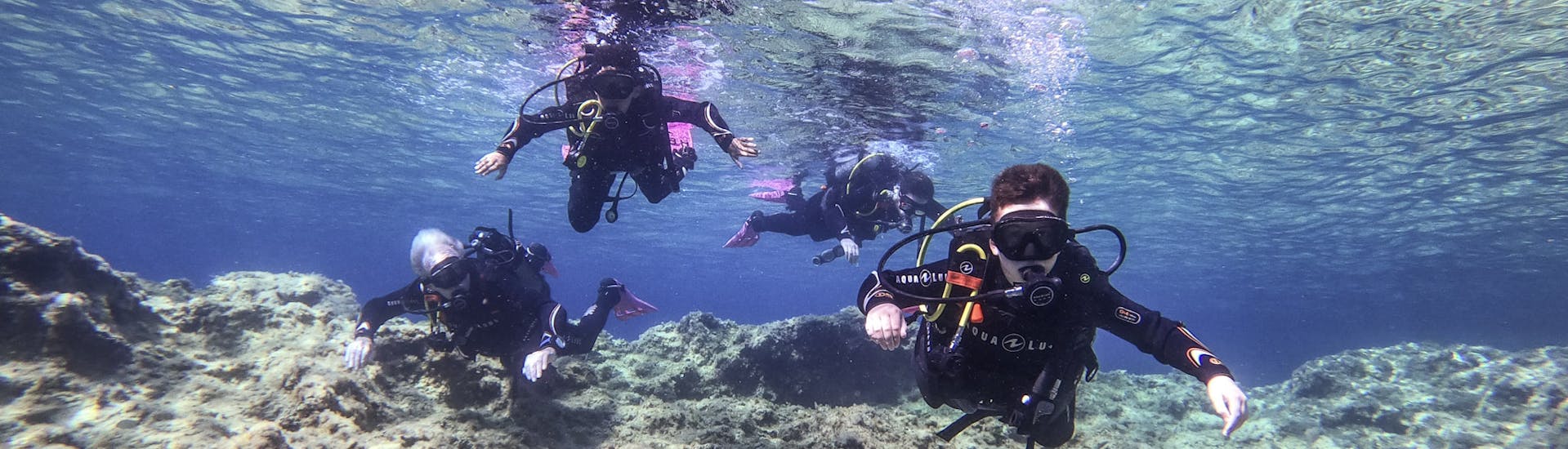 4 mensen die aan het duiken zijn tijdens de Discover Scuba Duiken voor beginners van ABC Diving Malta.