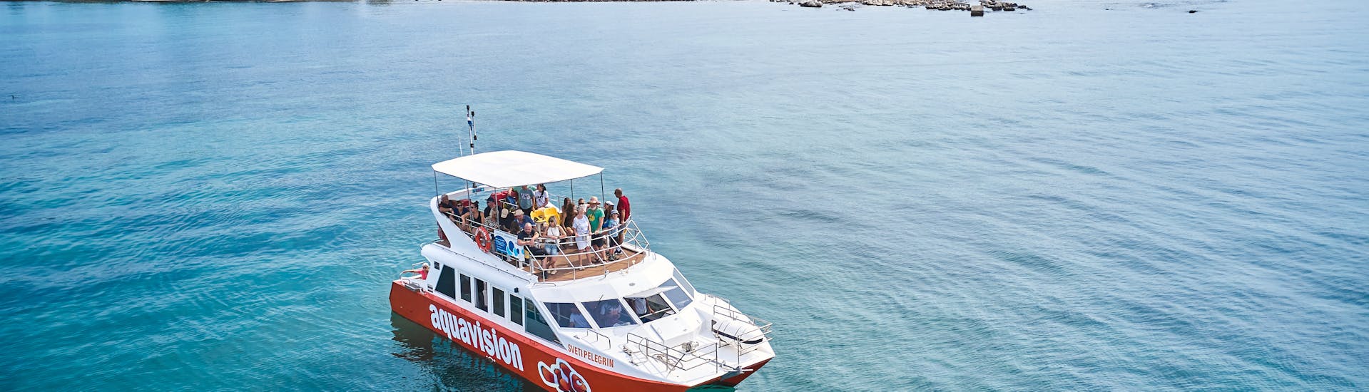 Aquavision's Glassbottom Catamaran where people are enjoying the views on the sundeck.