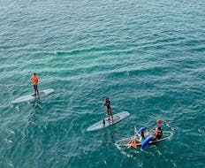 People standing on a paddle board organized by Clear Emotions.