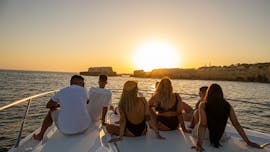 Eine Gruppe von Leuten genießt die untergehende Sonne während der Privaten Sonnenuntergangs-Bootstour entlang der Algarve zur Benagil Höhle organisiert von EasyDream Charters.