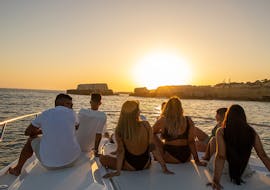A group of people enjoys the setting sun while doing a Private Sunset Boat Trip along the Algarve to the Benagil Cave organized by EasyDream Charters Albufeira.