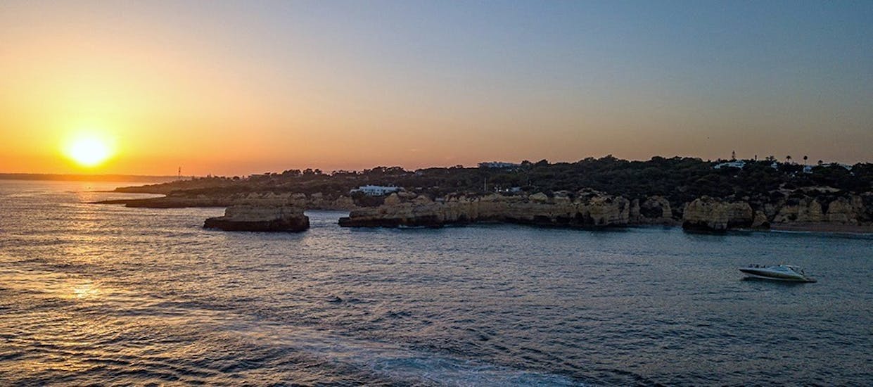 A yacht sails into the sunset while doing a Private Sunset Boat Trip along the Algarve to the Benagil Cave organized by EasyDream Charters Albufeira.