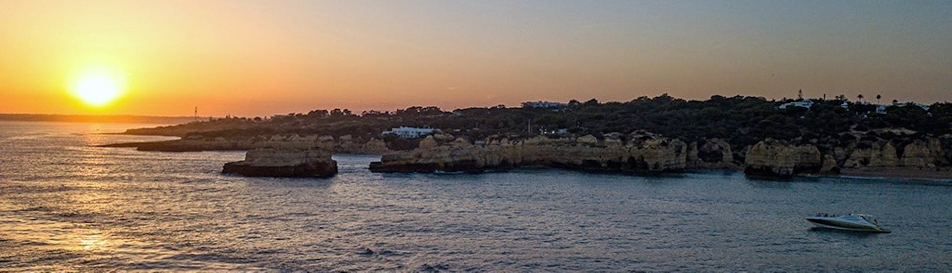 A yacht sails into the sunset while doing a Private Sunset Boat Trip along the Algarve to the Benagil Cave organized by EasyDream Charters Albufeira.
