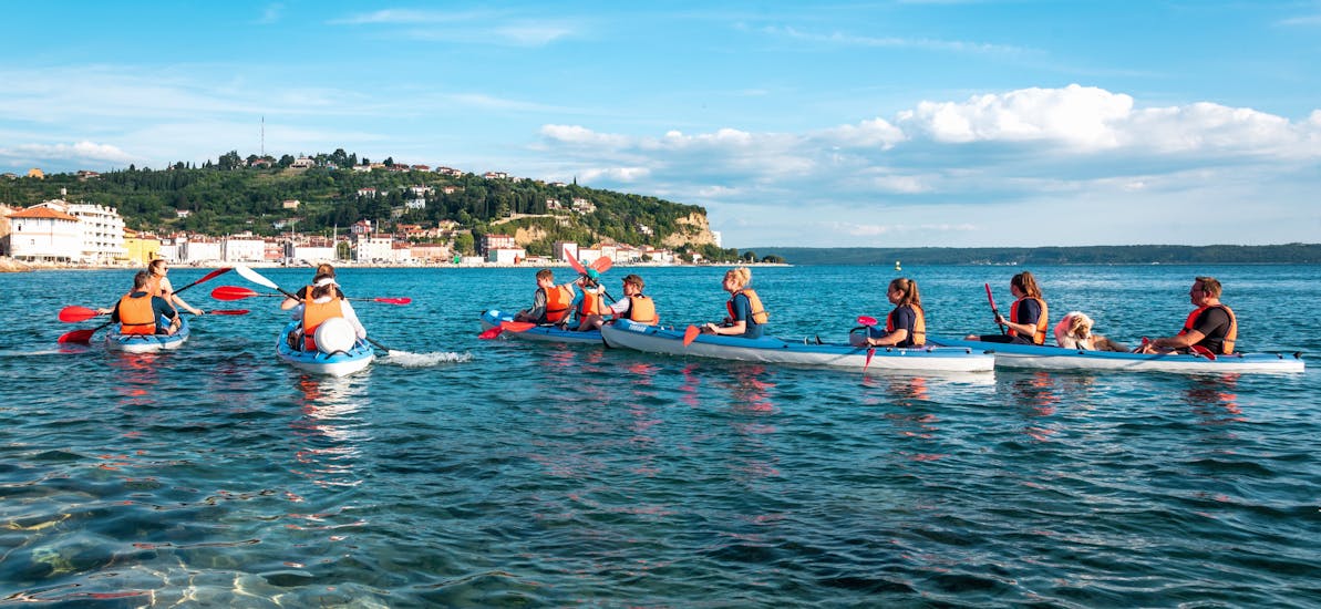 People paddling on their kayaks during their Morning Sunlight Sea Kayak Tour from Piran.