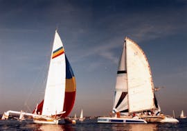 Two catamaran racing during the 80s. One of them is the Half-Day Catamaran-Trip on Grau-du-Roi Coasts skipper from Voilemed.