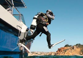 Side angle of an open water diver jumping into the clear blue water near Lagos from the WeDive Lagos boat.