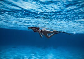 Een vrouw die aan eht snorkelen is in het helder blauwe water tijdens de Prive boottocht in Istrië met snorkelen en klifspringen met Istra Speed Boat.