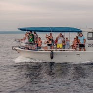 Menschen auf dem Boot während der Delfinbeobachtungs-Tour während dem Sonnenuntergang in Fažana mit Brijunu Panorama Istria.