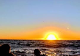 Mensen kijken naar de zonsondergang tijdens de boottocht georganiseerd door Malta Explorers.