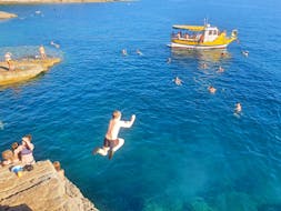 A guy jumps in the water while doing a Boat Trip from Fažana to the Seagulf Caves with Snorkeling from Rea Excursion Fažana.
