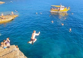 A guy jumps in the water while doing a Boat Trip from Fažana to the Seagulf Caves with Snorkeling from Rea Excursion Fažana.