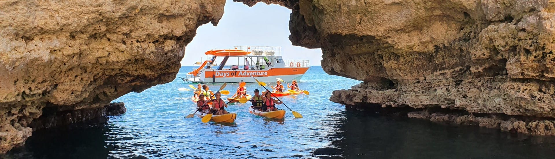 People kayaking underneath rocks during the Private Sea Kayaking Tour at the Caves of Ponta da Piedade.