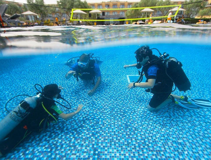 Half submerged camera image showing the scuba rangers from WeDive Lagos in the pool below the surface, while above the surface a volleyball net spans across the pool.