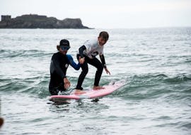 Boy on a surfboard during his Private Surf Lessons (from 5 y.) in Brest Country from Minou Surf School Pays de Brest.