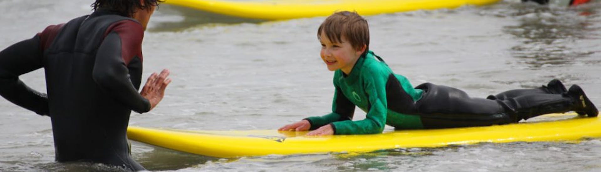 Boy learning how to surf with Minou Surf School Pays de Brest's Private Surf Lessons (from 5 y.) in Brest Country.