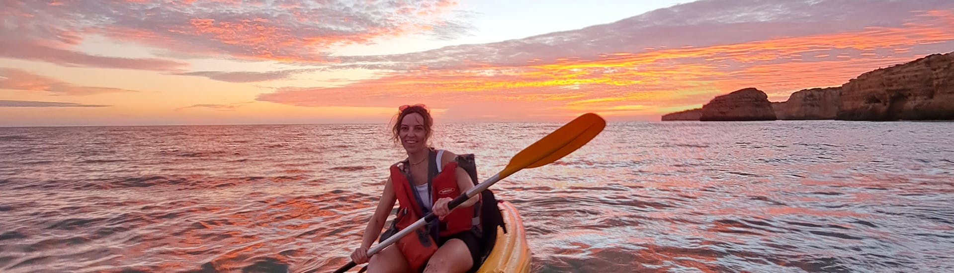 A woman enjoying our private Sunset Kayak Tour to the Benagil Caves and Marinha beach from Albandeira from Albandeira Ecotours.