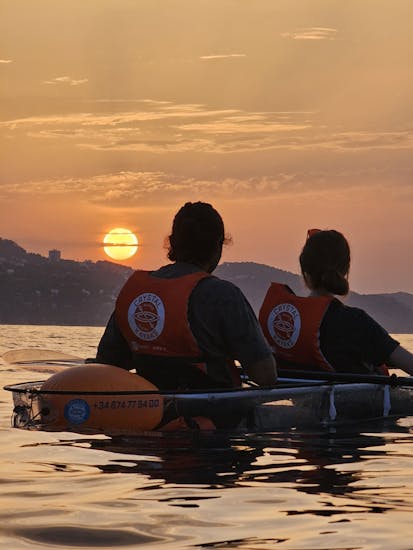 Beautiful Sunrise Sea Kayak Tour with trasnparent kayaks around Blanes coves with Crystal Kayaks Blanes