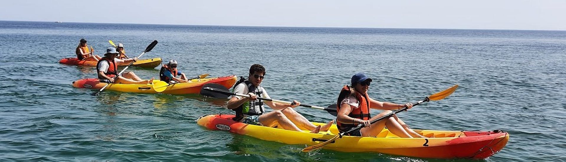3 kayaks with 2 people per kayak relaxing on the water during the Kayak Tour in Salema through Caves from Salema Tours.